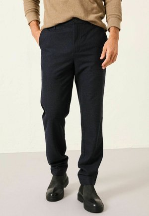 Marineblaue Wollhose mit glatter Textur, taillierter Passform und Fronttaschen, kombiniert mit schwarzen Lederstiefeln.