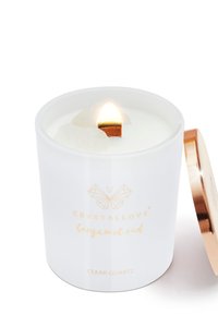 Candela in ceramica bianca con stoppino in legno, accesa. Include un logo dorato e un coperchio, etichettata "Bergamot Oud" e "Clear Quartz."