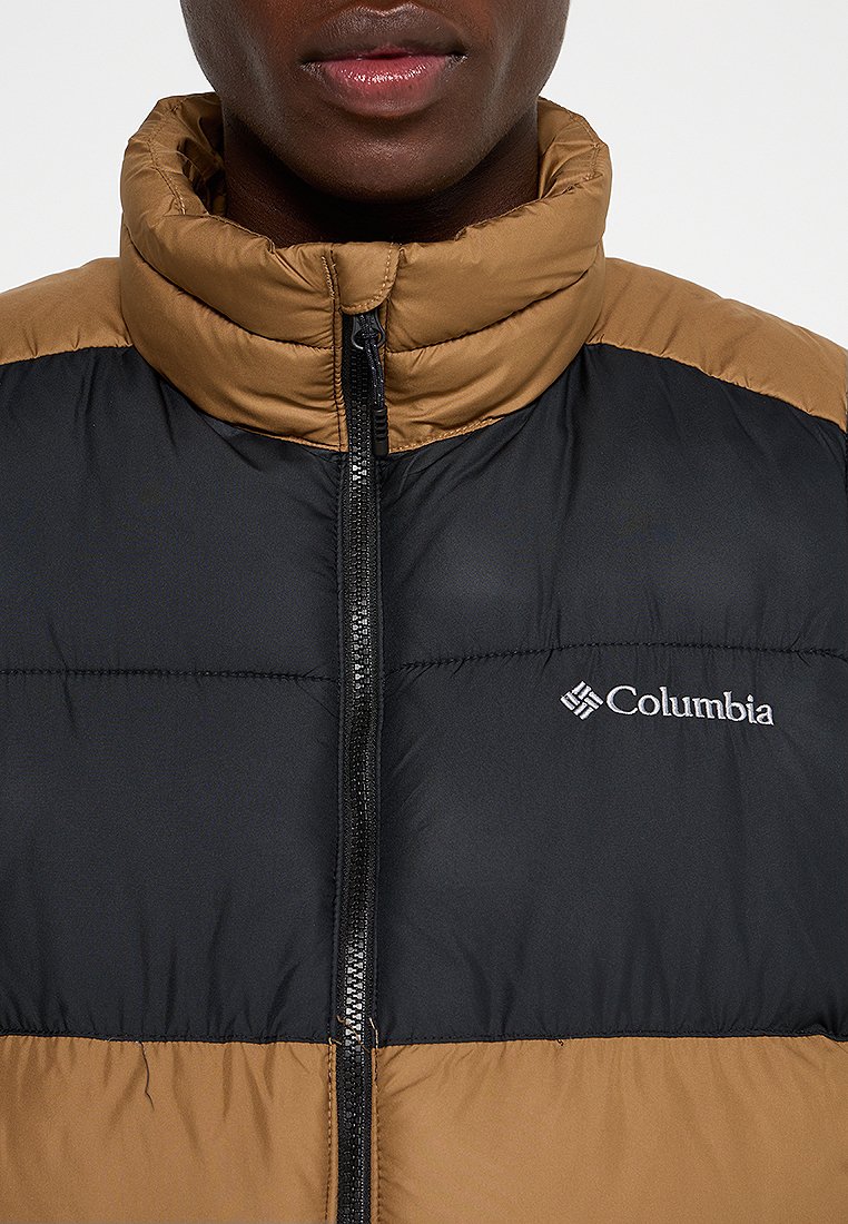 Kurtka puchowa z czarną dolną częścią i brązową górną, z wysokim kołnierzem i zamkiem z przodu, z logo "Columbia" na klatce piersiowej.