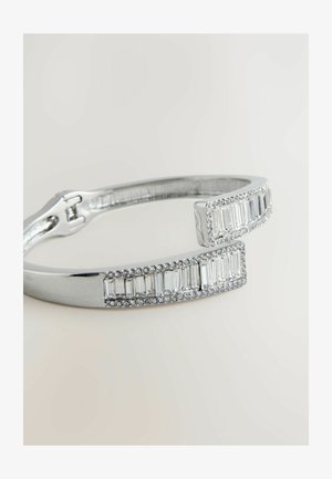 Hõbedane käevõru, millel on ristkülikukujulised aktsendid ja selged kivid, sile viimistlus ja turvaline haak. Laius umbes 6 mm.