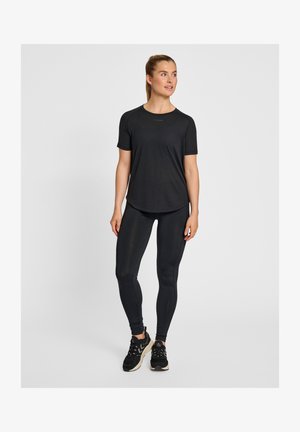 Sort atletisk t-shirt og tights lavet af blødt, strækbart materiale. Minimalistisk design med korte ærmer og buet kant; parret med sorte sneakers.