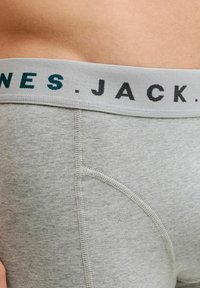 Vaaleanharmaat alushousut, joissa on pehmeä vyötärö, jossa on tummansinisellä ja mustalla painettu "JACK". Miellyttävä pinta, jossa on litteät saumat.