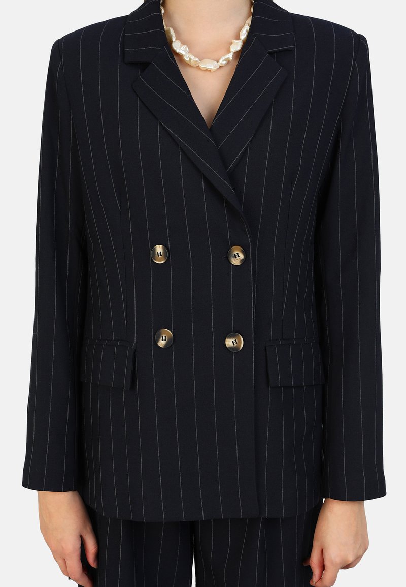 Blazer croisé à double boutonnage en tissu texturé à rayures bleu marine, avec des boutons dorés et deux poches avant.