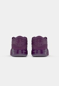 Ljubičasti Nike Air tenisice s glatkom kombinacijom suede materijala i gume. Sadrže urezane logotipe i prozirnu potplat. Pogled straga.