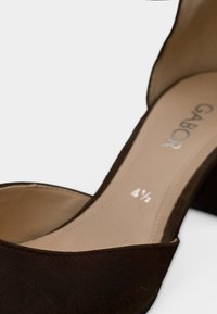 Chaussure à talon haut en daim marron avec semelle intérieure beige, indiquant la taille 4½ et le nom de la marque Gabor visible à l'intérieur.