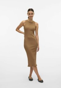 Vestido midi de canalé color marrón con diseño sin mangas, que presenta un cuello alto y una silueta ajustada, combinado con bailarinas negras texturizadas.