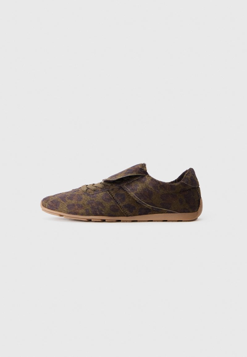 Chaussure à imprimé léopard en tissu avec une texture douce, présentant un bout rond, une sangle Velcro et une semelle flexible de couleur beige.