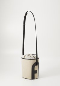 Geantă tip bucket din piele maro și pânză bej, cu curea ajustabilă, închidere cu șnur și un accent negru proeminent pe latură.
