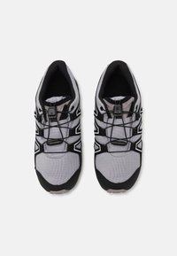 Gray and black athletic shoes featuring a textured upper material, elastic laces, and a cushioned insole with a reinforced toe area.