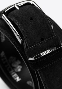 Schwarzer Wildledergürtel mit silberfarbenem Metallverschluss, der ein Logo-Highlight und mehrere Löcher zur Anpassung aufweist, mit einer glatten Textur.