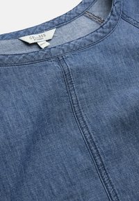 Topp i denimblått med rund halsringning, centralseamsdetalj och synlig vit etikett med texten "CELLBES OF SWEDEN" storlek 38/40.