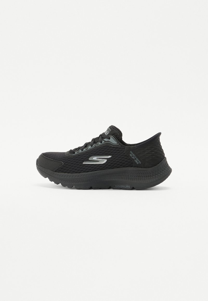 Black athletic shoe with a textured mesh upper, cushioned sole, and prominent side logo. Includes laces and a rounded toe design.