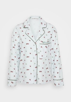 Długosleeve'owa piżama w białym kolorze z czerwonym i zielonym nadrukiem w tematyce świątecznej, z kontrastującymi zielonymi lamówkami oraz kieszenią z przodu.