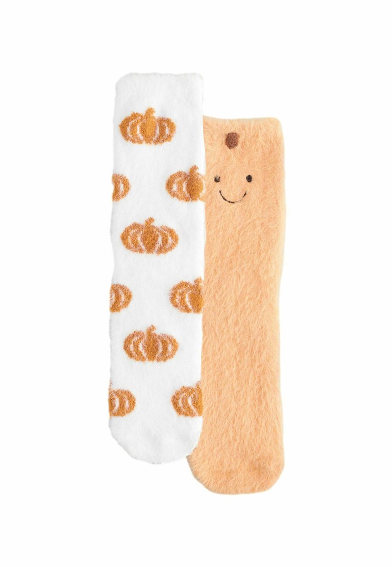 Ein Paar flauschiger Socken, eine weiß mit orangefarbenen Kürbismustern, die andere hellorange mit einem lächelnden Gesicht oben.