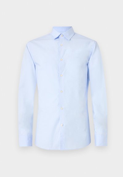 Camisa de mangas longas azul clara com colarinho pontiagudo, fecho frontal com botões e mangas com punhos. Tecido de algodão suave com um brilho sutil.