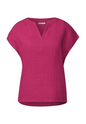 Top fucsia de manga corta con escote en V y corte relajado. Confeccionado en tejido texturizado, presenta un dobladillo ligeramente curvado y sin cierres visibles.