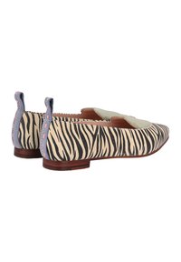 Scarpe flat con tomaia in tela a stampa zebra, accentuazione in suede verde e tacco corto in legno. Presentano un retro ad anello e cuciture a contrasto.