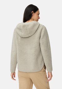 Fleecejack in lichtgrijs, met een capuchon, textuur stof en een ontspannen pasvorm. Zichtbare stiksels en zakken aan de zijkanten.