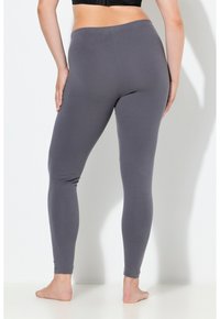 Leggings grises hechos de un material suave y elástico. Diseño ajustado con una pretina elástica, textura lisa y sin patrones o detalles visibles.