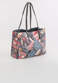 Bolso de mano colorido con un patrón floral en rosa, azul y amarillo sobre un fondo oscuro; con asas dobles; textura suave.