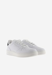 Baskets en cuir blanc avec un accent texturé noir au niveau du talon, bout rond, détails perforés et semelle rembourrée.