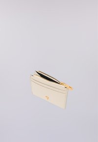Portafoglio in pelle beige con zip, dotato di hardware dorato, più slot per carte e una texture liscia.