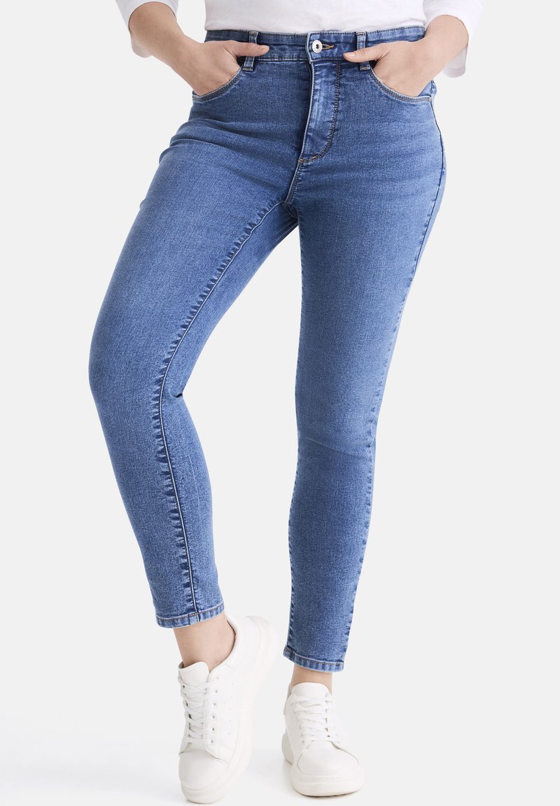 Schmale Jeans aus blauem Denim mit hoher Taille, ausgestattet mit fünf Taschen, einem Reißverschluss und einem Knopfverschluss sowie einer leicht abgewetzten Textur.