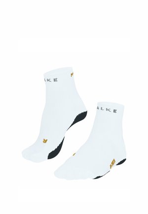 Paar weiße Knöchelsocken mit schwarzen Sohlen, gebrandetem Schriftzug nahe den Bündchen und kleinen goldenen Buchstaben an Zehen und Seiten.