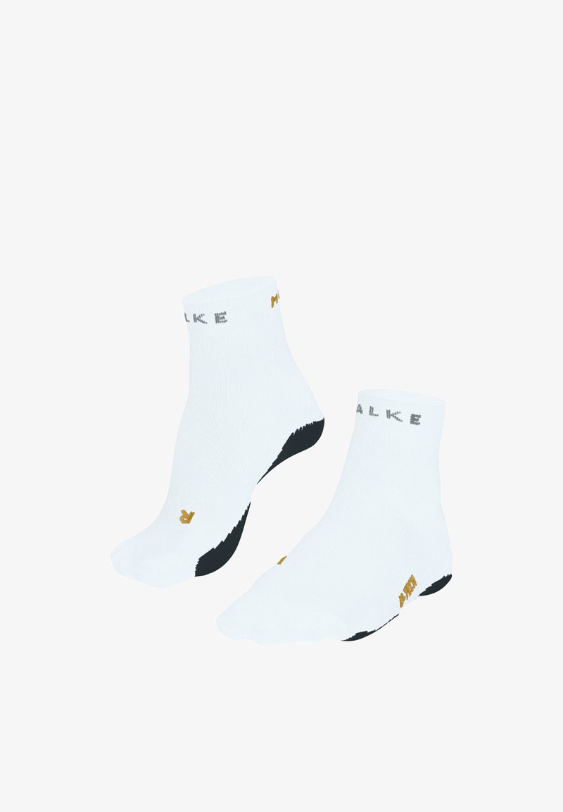 Paire de chaussettes blanches à chevilles avec semelles noires, texte de marque près des poignets, et petites inscriptions dorées sur les orteils et les côtés.