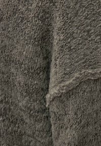Textured grey fabric with a soft, fluffy surface, featuring raised loops and alternating patterns for added depth and interest.