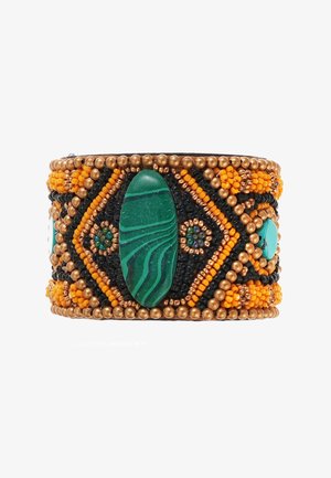 Bracelet manchette perlé avec une pierre de malachite verte, des perles de rocaille orange et noires, et des accents dorés dans un motif géométrique.