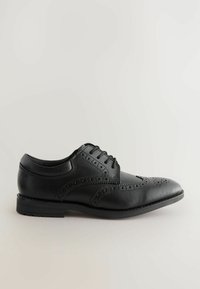 Chaussure habillée en cuir noir avec des détails en brogue, design à lacets, bout rond et une semelle en caoutchouc texturé basse. Fini lisse et construction robuste.