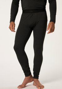 Schwarze Thermoleggings aus weichem, dehnbarem Material, mit einem engen Schnitt und einem elastischen Bund mit "SPORTS"-Branding.
