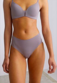 Soutien-gorge violet clair et culotte taille haute en tissu doux. Le soutien-gorge possède des bretelles réglables et des bonnets sans coutures pour un ajustement épuré.