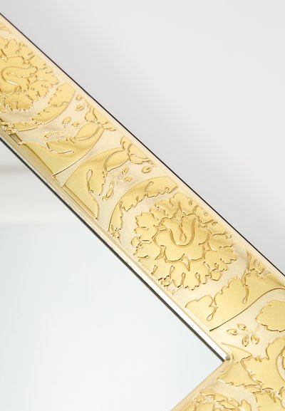 Lustro z akcentami złota, z ozdobną ramą zdobioną kwiatowymi grawerunkami, z gładką, refleksyjną powierzchnią i misternymi detalami na krawędziach.