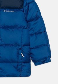 Blå puffjakke med en glinsende finish, med en glidelåslomme, elastiske mansjetter og en logo på brystet. Lett isolasjonsdesign.