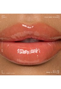 Glänzende, glatte Lippen mit einem lebendigen orangen Jelly-Lippen-Gloss, der die natürliche Hautstruktur um den Mund zeigt.
