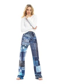 Pantalones de patchwork de mezclilla con diferentes tonos de azul, con detalles desgastados y un diseño acampanado. Combinados con una blusa blanca de manga larga.