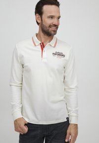 Langærmet polo skjorte i off-white bomuld med røde detaljer på kraven og placket. "Authentic Performance" broderet i mørkerød.