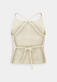 Light yellow fitted top with a cross-back design, adjustable tie at the waist, and smooth texture. No visible patterns or hardware.