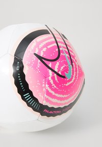 Nike jalgpall, millel on valge välimus, roosa ja musta geomeetrilised mustrid, tealiahine logo ning sile sünteetiline tekstuur.