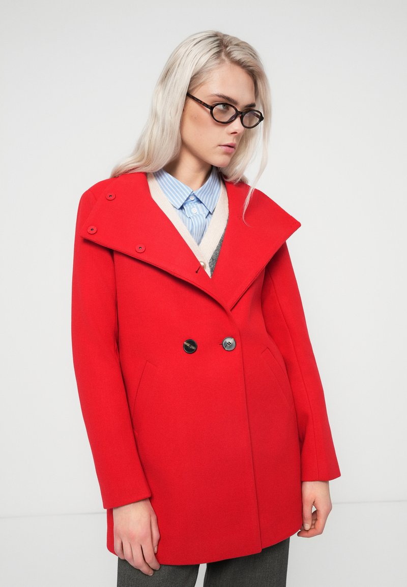 Rote Wollmischung Jacke mit einem doppelreihigen Design, übergroßem Kragen und großen schwarzen Knöpfen. Mit seitlichen Taschen und figurbetontem Schnitt.