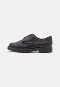 Chaussure oxford en cuir noir avec un embout arrondi, des détails cousus et une semelle en caoutchouc texturé. Présente un système de laçage classique.
