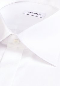 Chemise blanche à col pointu avec un bouton visible sous le col, étiquette « seidensticker » à l'intérieur de l'encolure.