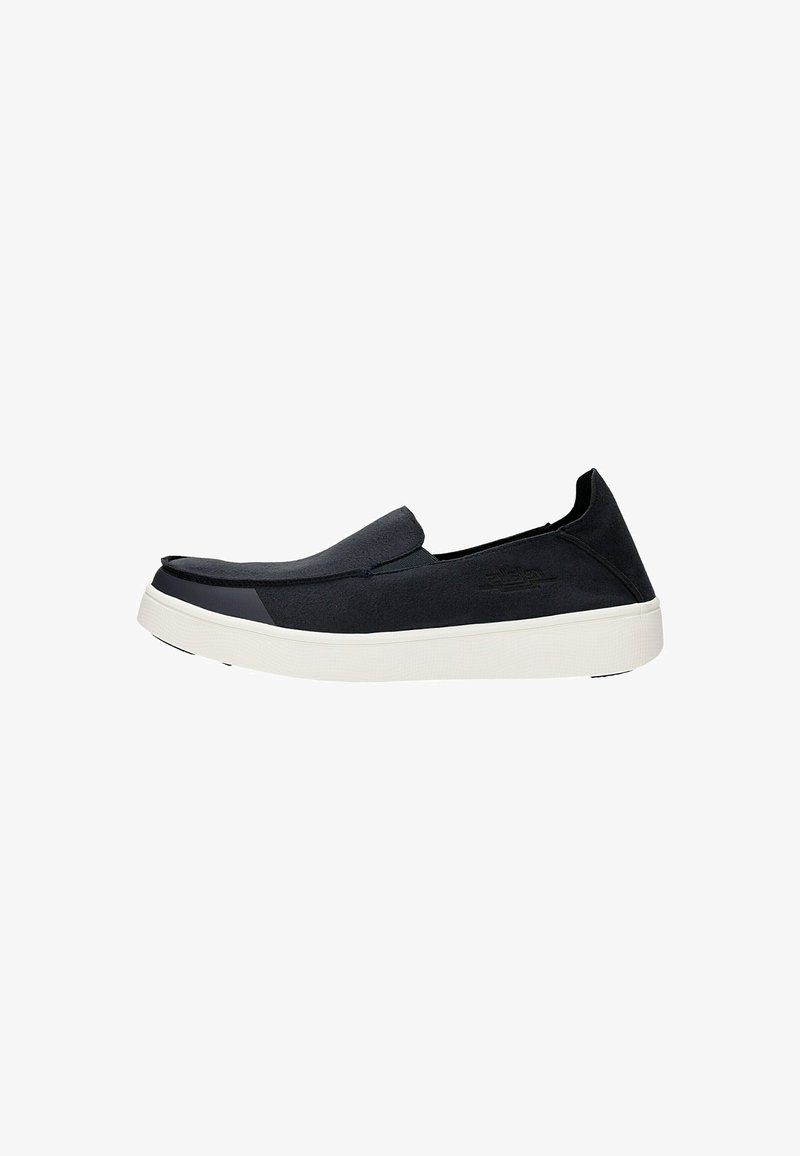 Scarpe slip-on nere con tomaia in suede liscio e suola in gomma bianca. Presentano un design minimalista con un leggero rialzo nella punta.