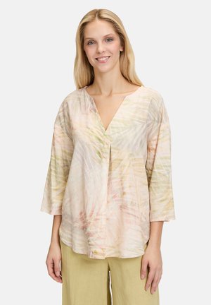 Leichte Bluse mit kurzen Ärmeln und V-Ausschnitt, die ein pastellfarbenes Blumenmuster in rosa, grün und gelb aufweist. Texturiert.