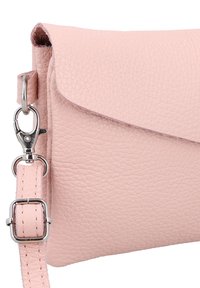 Bolso bandolera de cuero rosa claro con acabado texturizado, cierre de solapa plegable y herrajes plateados en la correa ajustable.