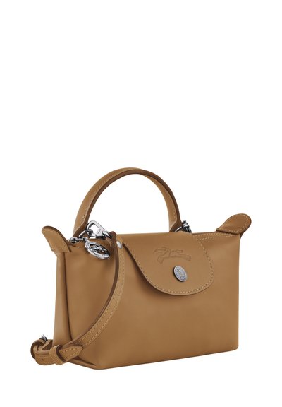 Tan leather handbag with a rounded shape, short handle, and detachable shoulder strap. Features a button closure and embossed logo detail.