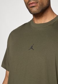 Ελιόχροσο κοντομάνικο μπλουζάκι από βαμβάκι με στρογγυλή λαιμόκοψη, που διαθέτει ένα μικρό μαύρο λογότυπο Jordan στο στήθος.