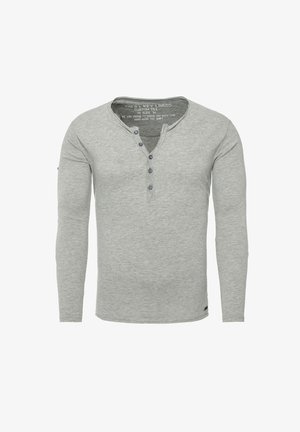 Camisa henley de manga larga en gris, hecha de un tejido suave, con una tapeta de botones y una textura sutil. Talla marcada como M.